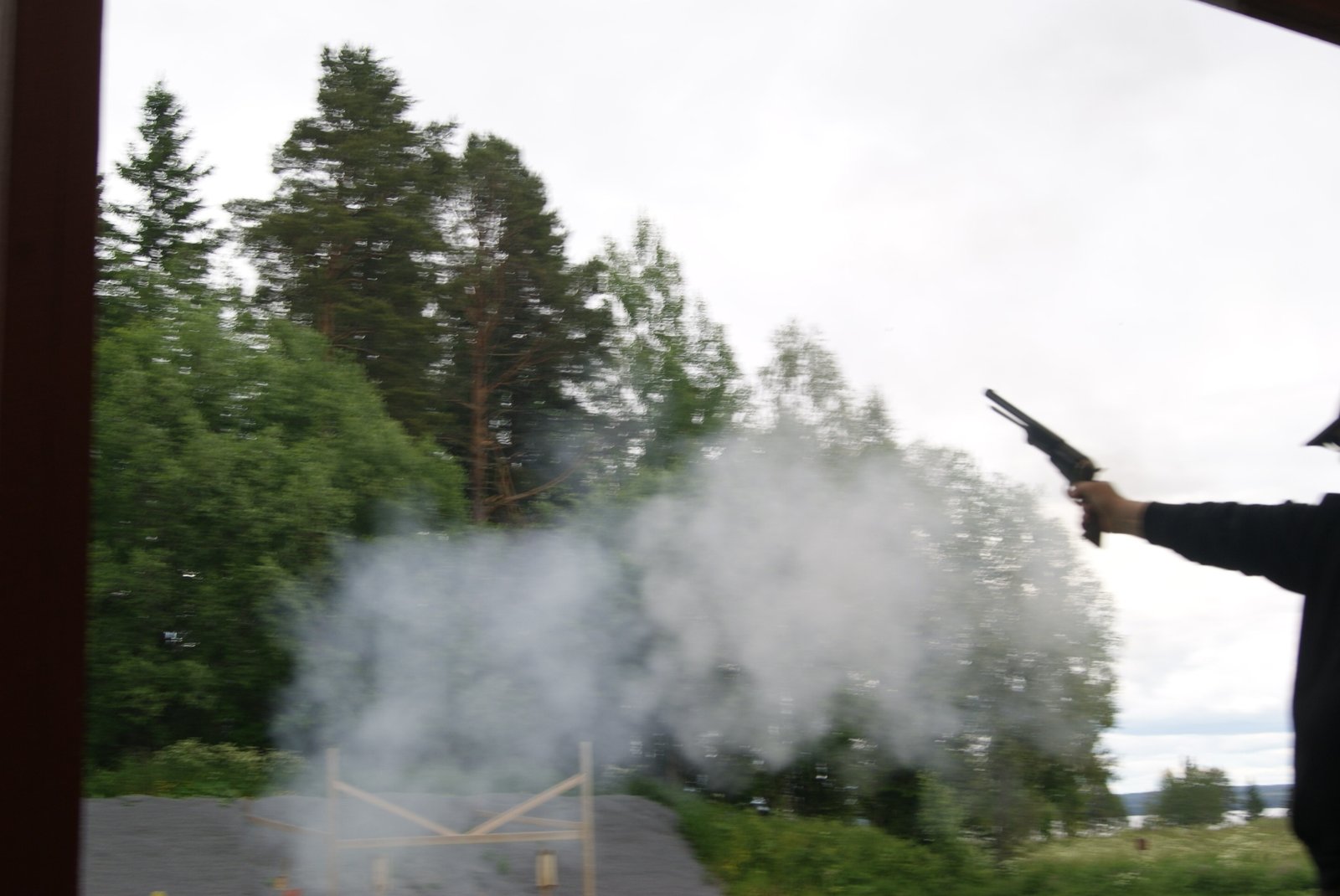 Svartkrutsrevolver avfyras vid skjutbanan, krutröken hänger kvar i luften
